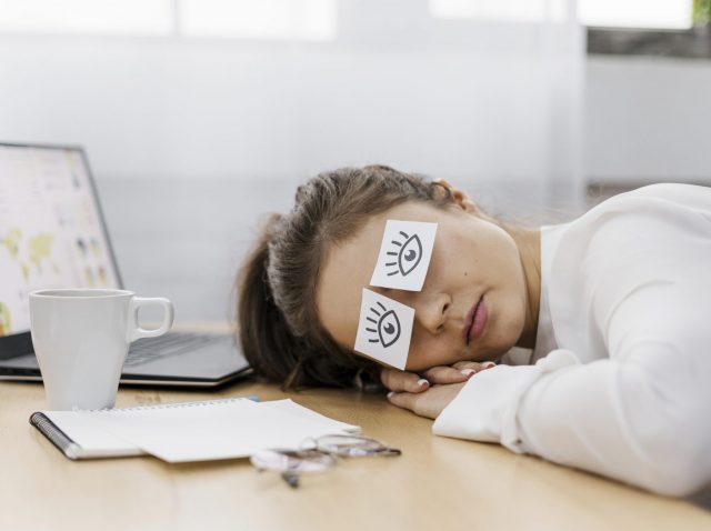 tired-businesswoman-covering-her-eyes-with-drawn-eyes-paper tired-businesswoman-covering-her-eyes-with-drawn-eyes-paper