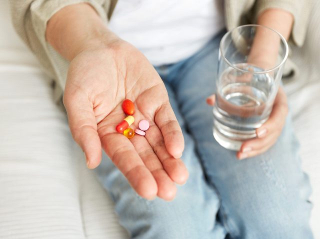 Pills, tablets, vitamins and drugs heap in mature hands, closeup view. Pills, tablets, vitamins and drugs heap in mature hands, closeup view.