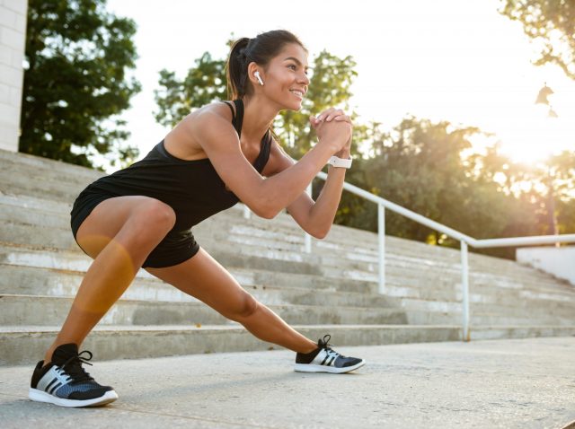 Portrait of a smiling fitness woman in earphones