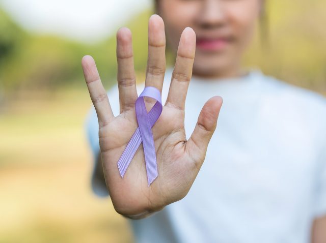 World cancer day (February 4). Woman hand holding Lavender purpl