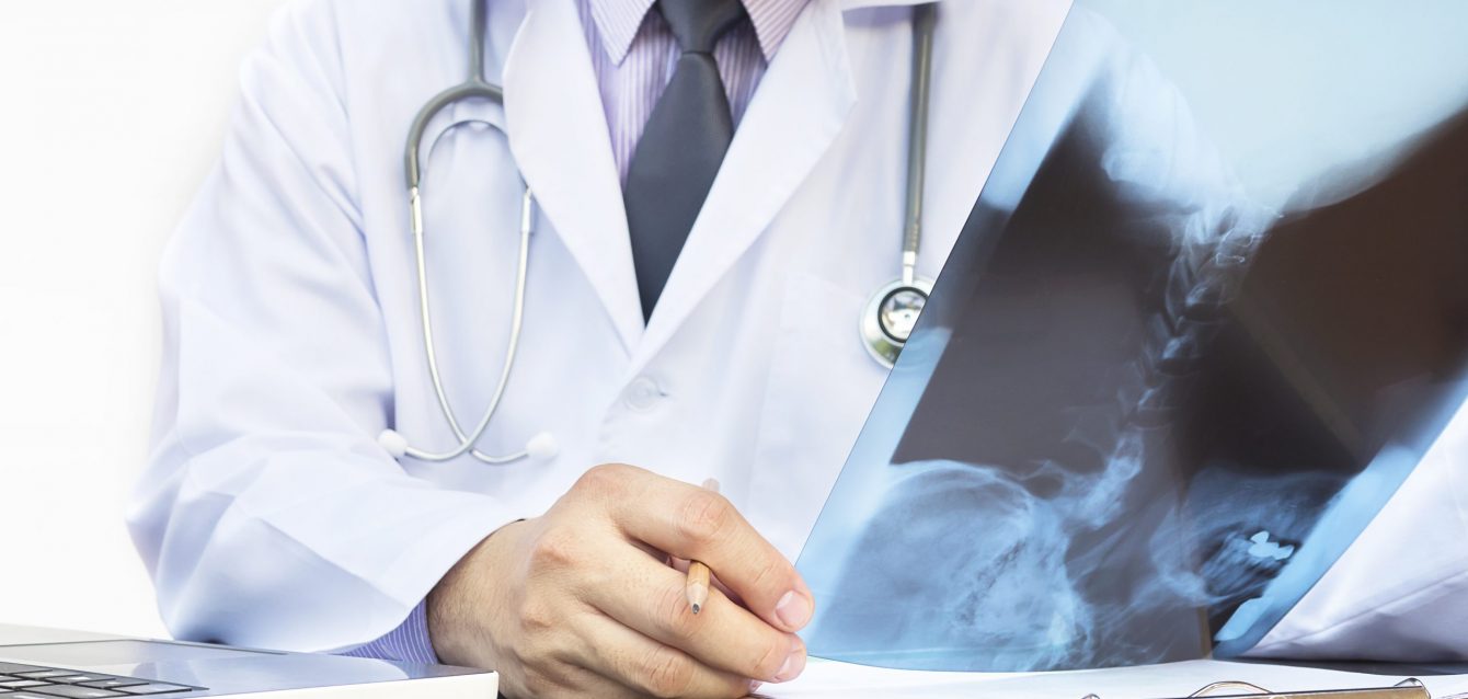 Doctor examine x-ray film over white background Doctor examine x-ray film over white background