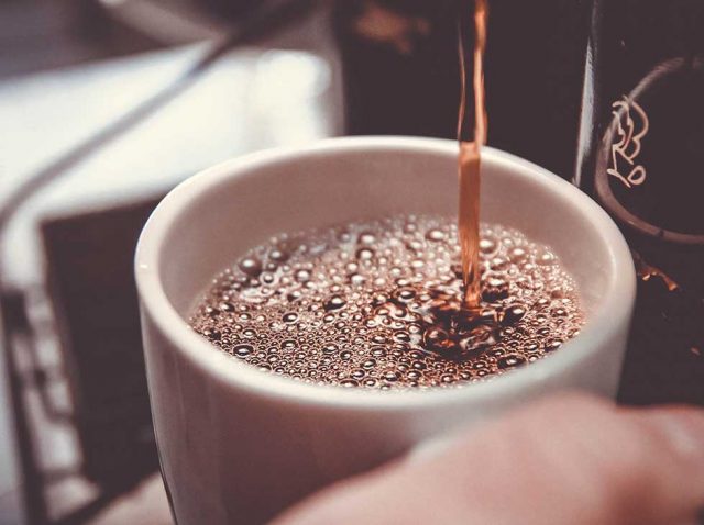 Café recién hecho sirviéndose en una taza Artículo sobre los efectos de la cafeína