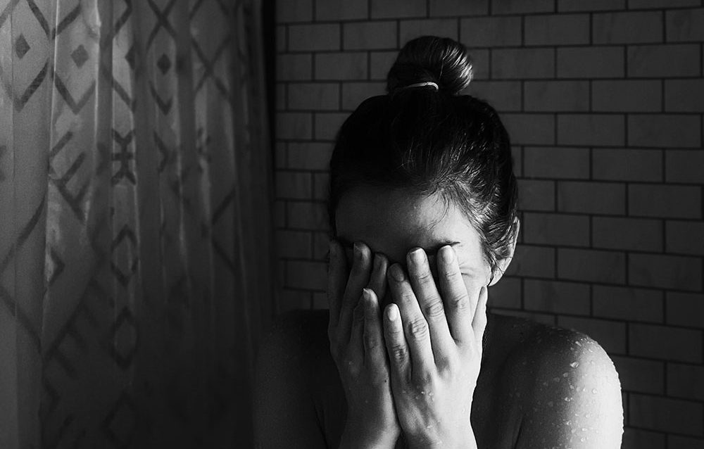 Una chica con problemas de ansiedad se cubre la cara antes de salir al escenario para ayudar a reducir el estrés.