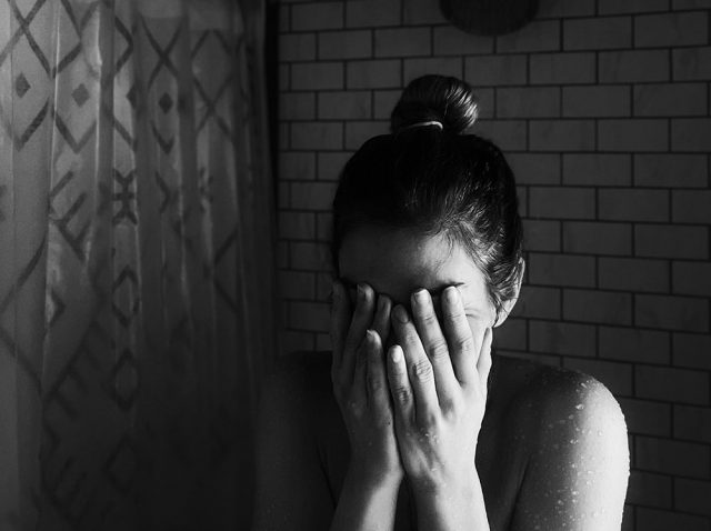 Una chica con problemas de ansiedad se cubre la cara antes de salir al escenario para ayudar a reducir el estrés.