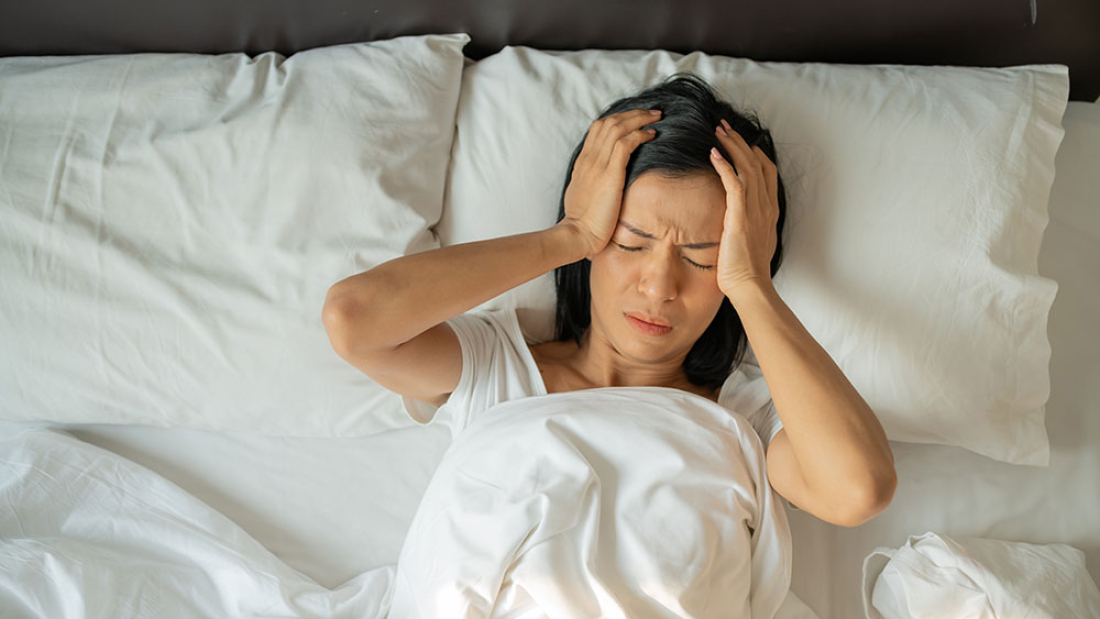 Mujer infeliz yace en la cama despierta por insomnio