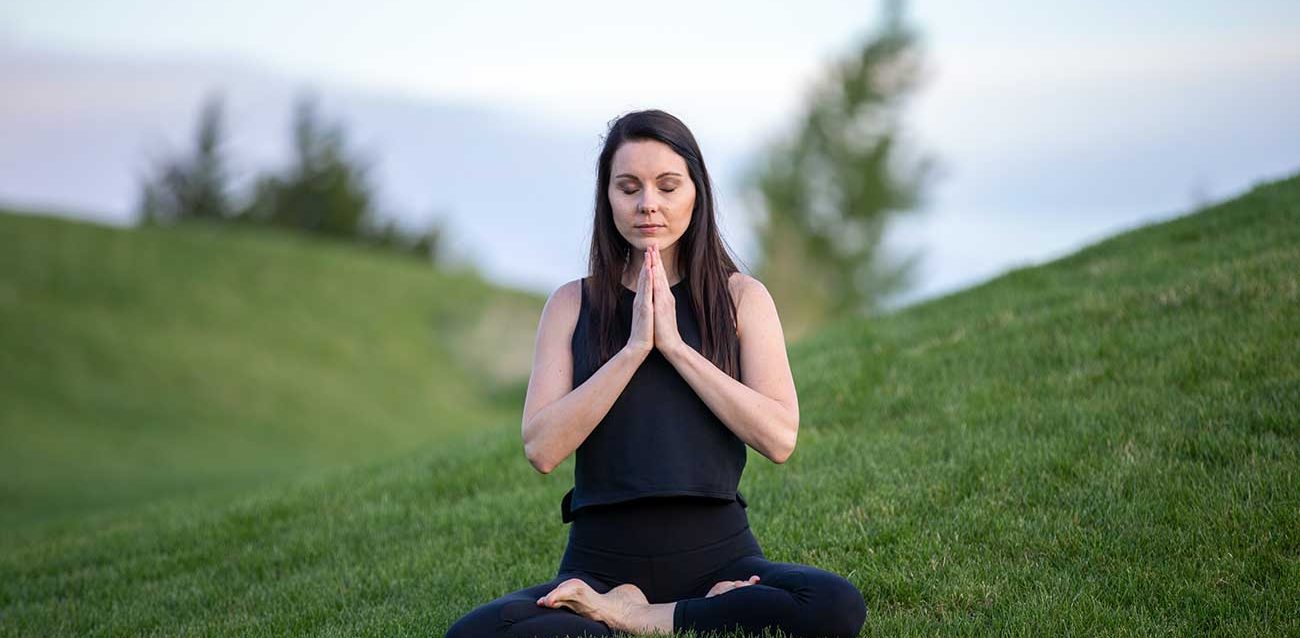 Foto de meditación de una mujer meditando en el campo
