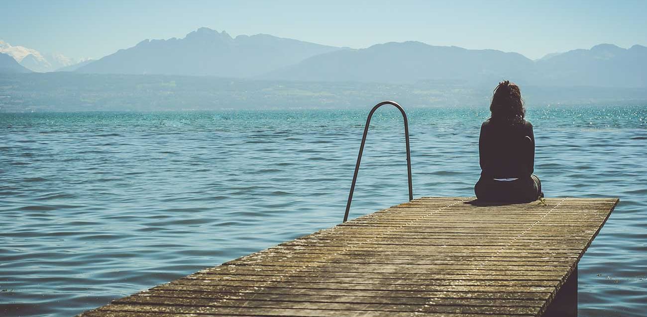 young-girl-experiencing-depression-site-on-pier-looking-over-lake Joven que sufre depresión en un muelle con vistas al lago