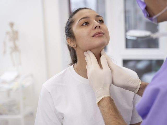 médico realizando un chequeo médico de rutina Examen de la tiroides para el diagnóstico de trastornos endocrinos.