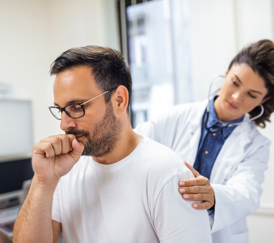 Una doctora de la clínica ausculta los pulmones de un paciente con síntomas de coronavirus o neumonía.