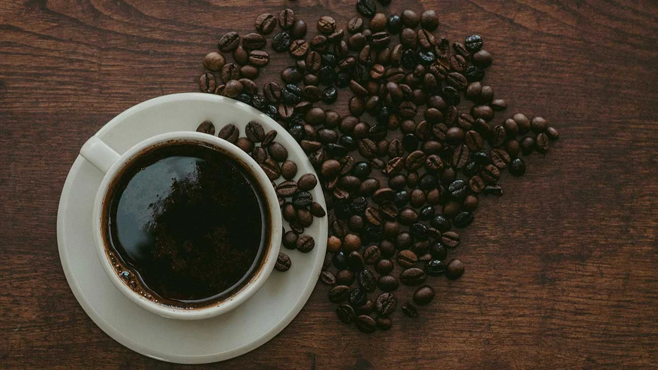 Foto del café en grano y en taza ¿El café provoca ansiedad?