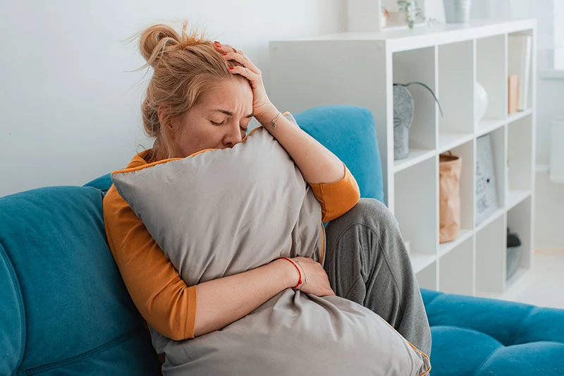 Ataque de pánico y ansiedad - Mujer estresada en el sofá